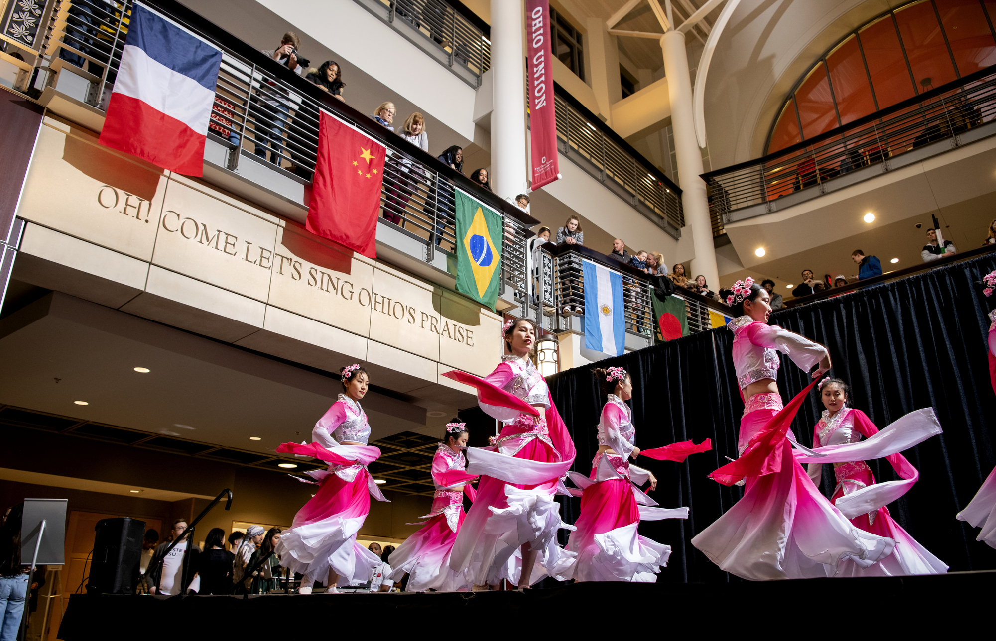 Dancers performing at Taste of OSU 2023 in front of different flags on a balcony