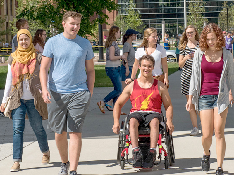 Four students walking together on Ohio State's campus.