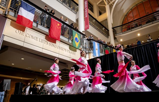 Dancers performing at Taste of OSU 2023 in front of different flags on a balcony